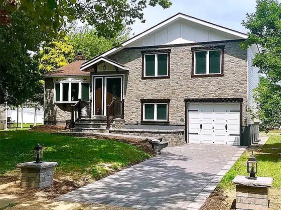 The finished home — new stone façade and paver drive